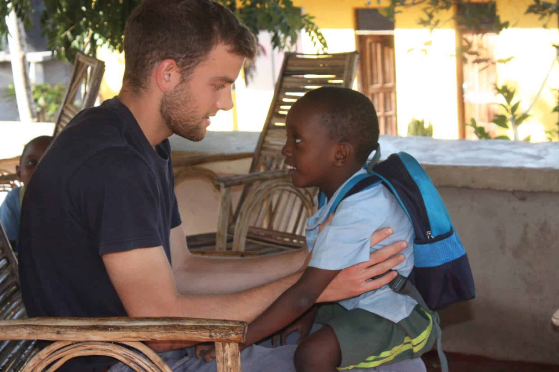 Community psychology volunteer engaging with a young child during an internship in Tanzania.