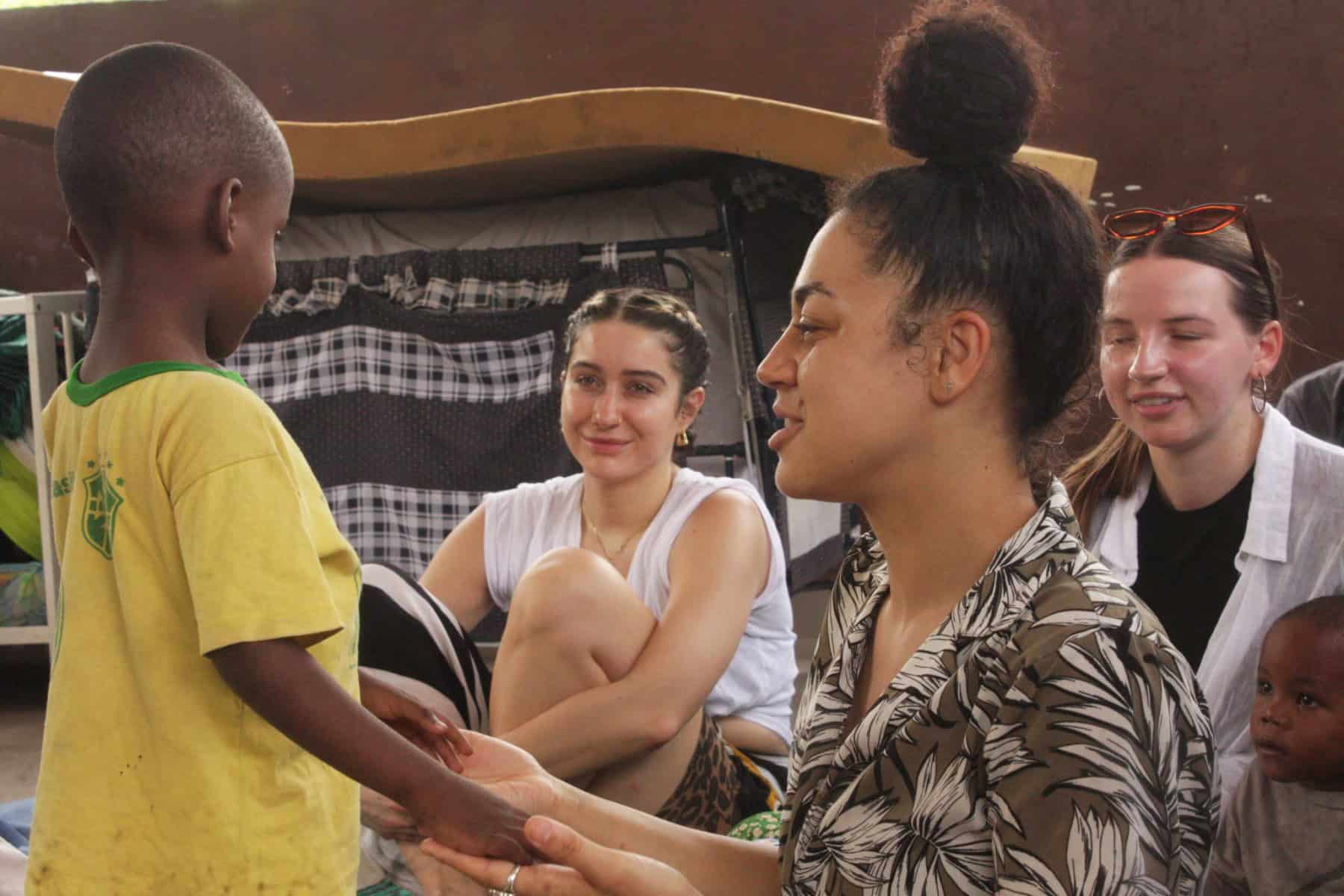 Volunteer educating local communities about corporate social responsibility during a business internship in Africa, contributing to sustainable business in Tanzania.