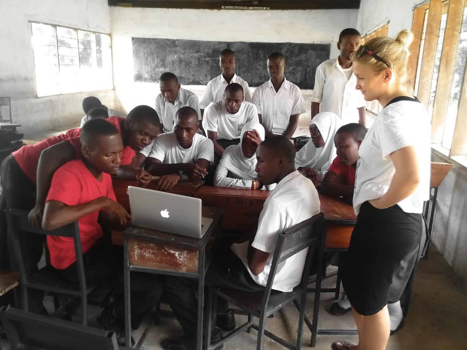 A group of students and a facilitator engaged in a human rights discussion during a volunteering and internships program in Tanzania.