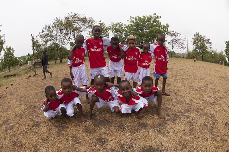 A children's soccer team posing on a field, representing Green Works Africa's volunteering and internship programs focused on village education and sports development.