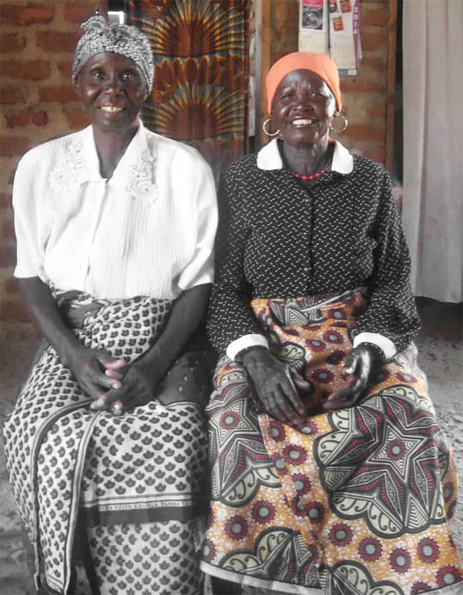 Two elderly women smiling as part of a social sector program supporting women’s empowerment and community development through volunteering initiatives.